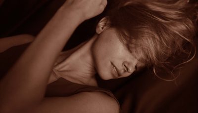 Femme en gros plan, visage détendu et connecté à elle-même, illustrant la détente et le plaisir féminin